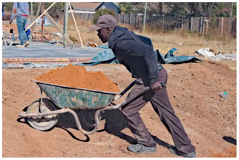 Man at work pushing barrow